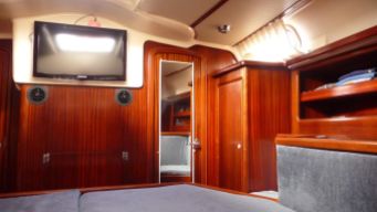 The view from the bed to the aft head the mirrored door leads there). The door to the left of the TV leads to the galley.